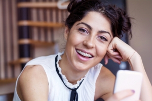 Young woman with braces holding phone